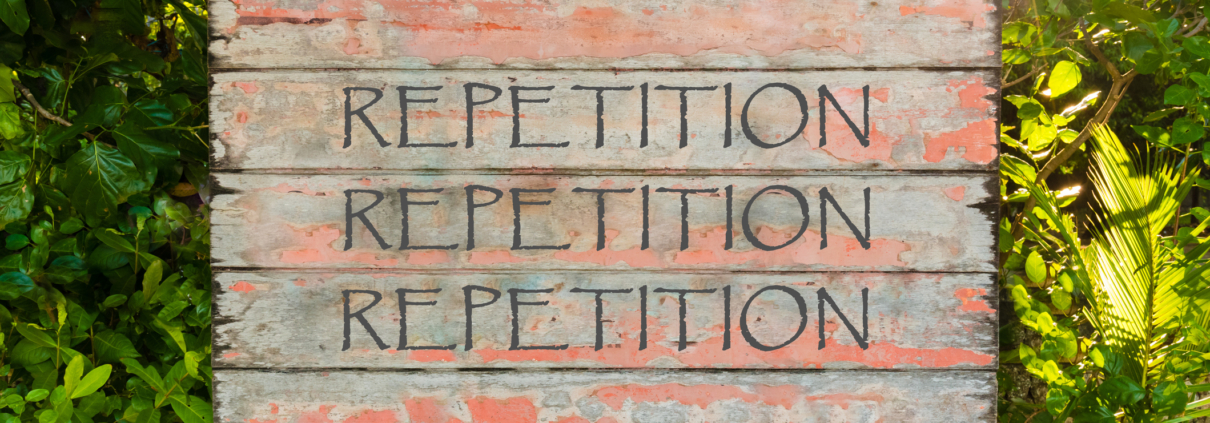 Wooden sign with the word repetition written on it three times with a woodland background