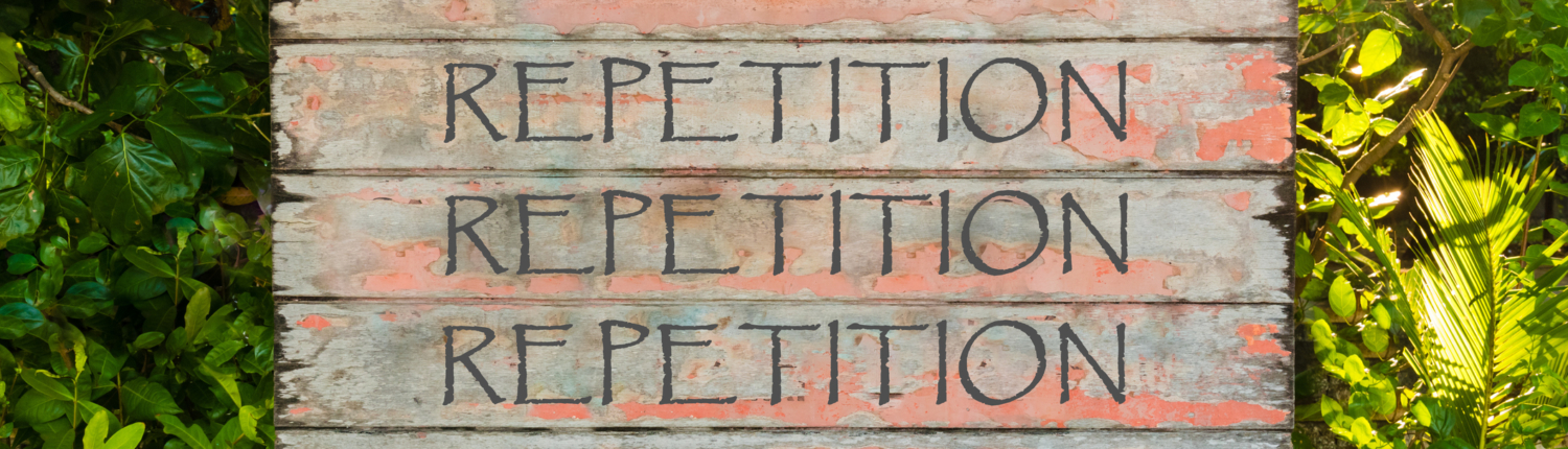 Wooden sign with the word repetition written on it three times with a woodland background