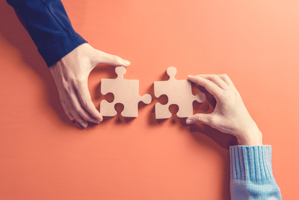 Two hands holding jigsaw pieces