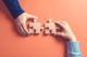 Two hands holding jigsaw pieces